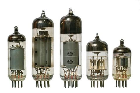 A set of five vintage vacuum tubes of varying sizes, standing upright. The glass tubes reveal intricate metal interiors, evoking a retro, technical feel.